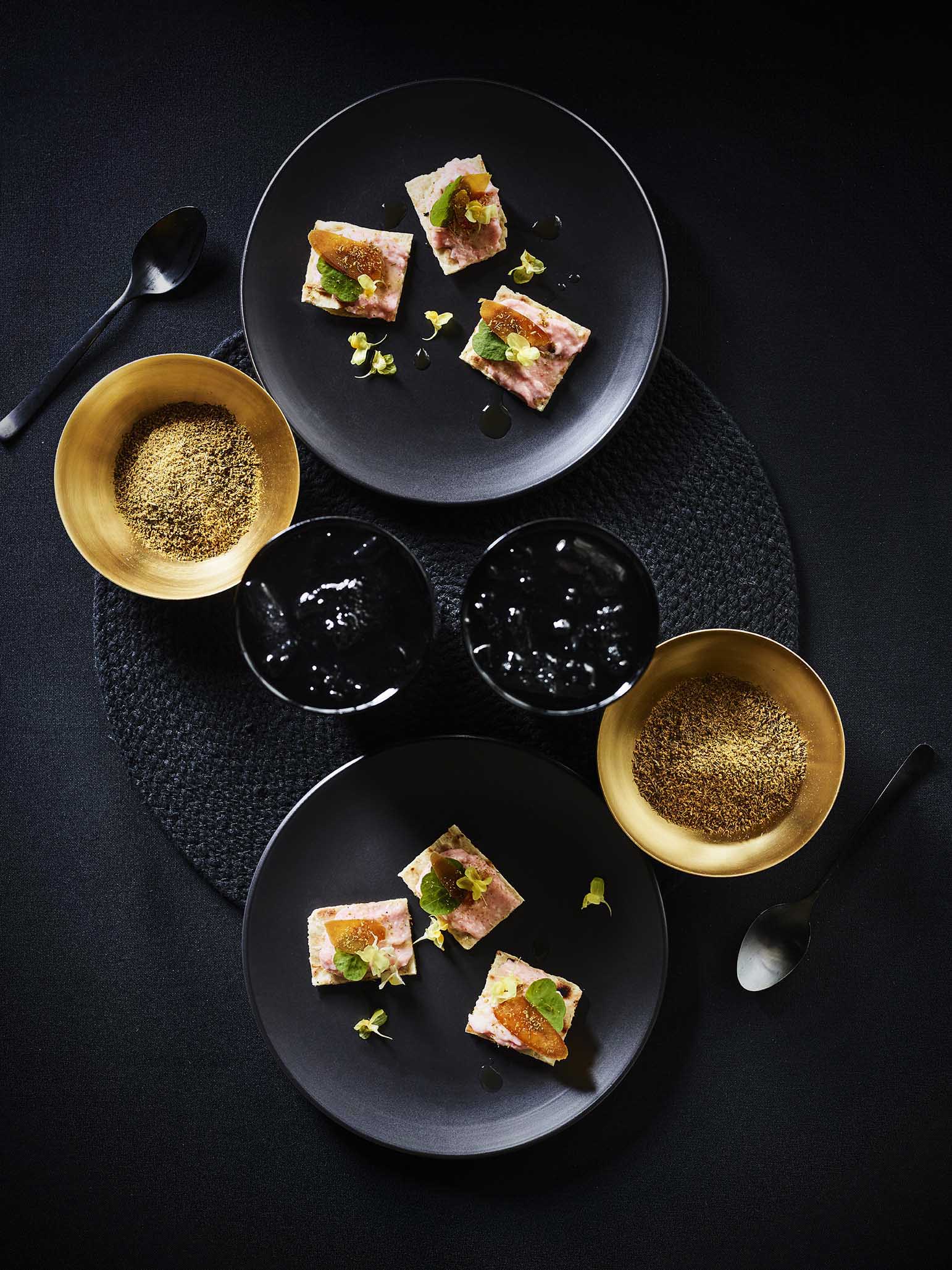 Gastronomy's hand made canapes presented on stylish black plates on table top
