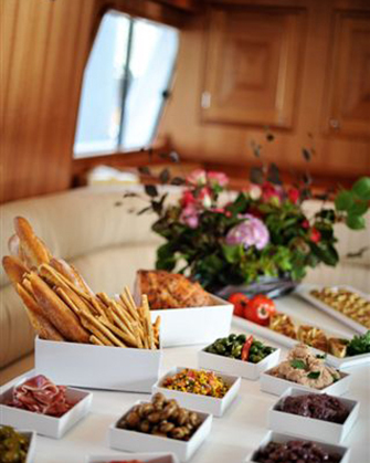 Antipasto selection displayed for lunch on Sydney boat with beautiful floral arrangement decorating table